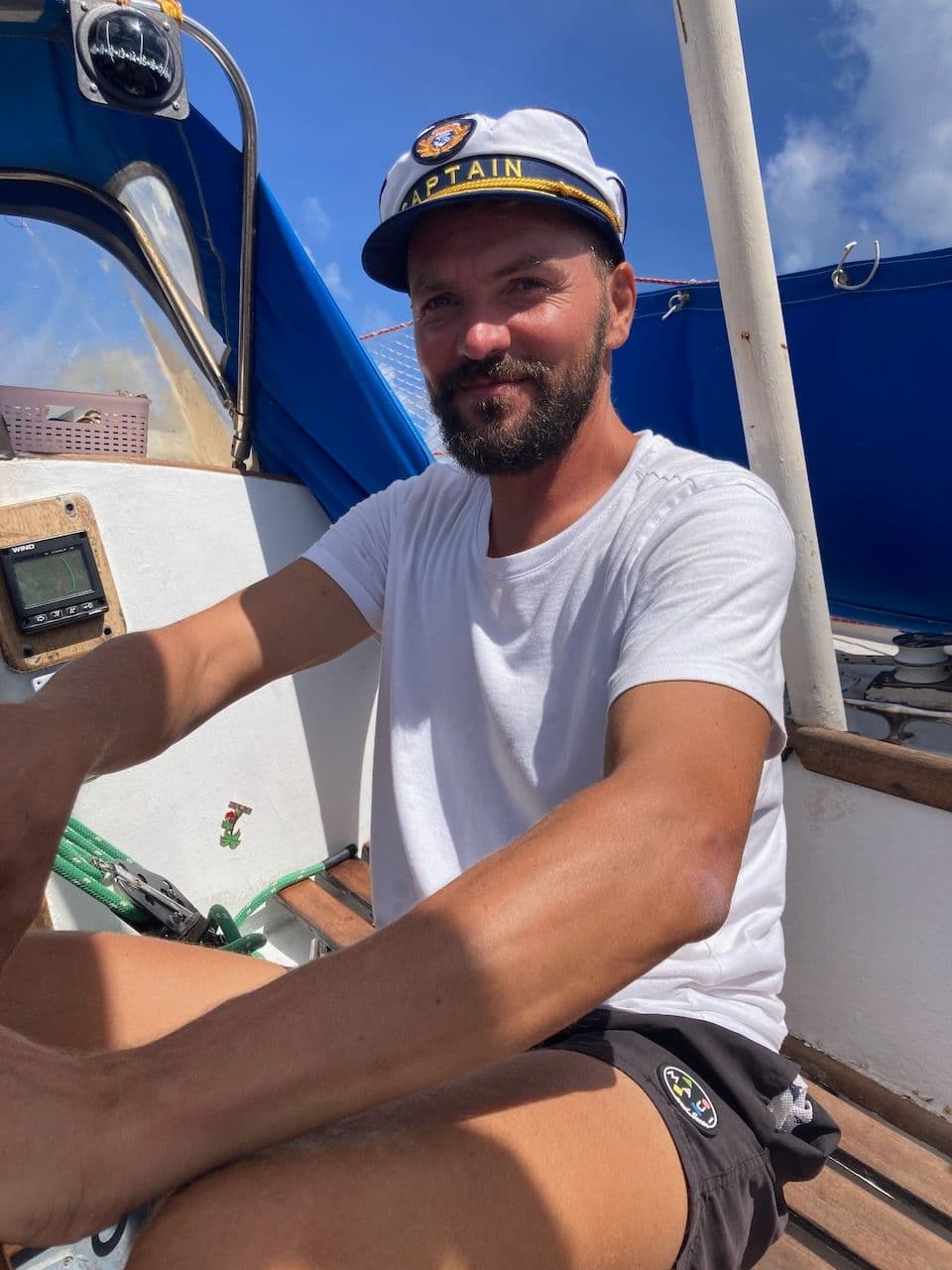 Miki in a captain's cap at the helm