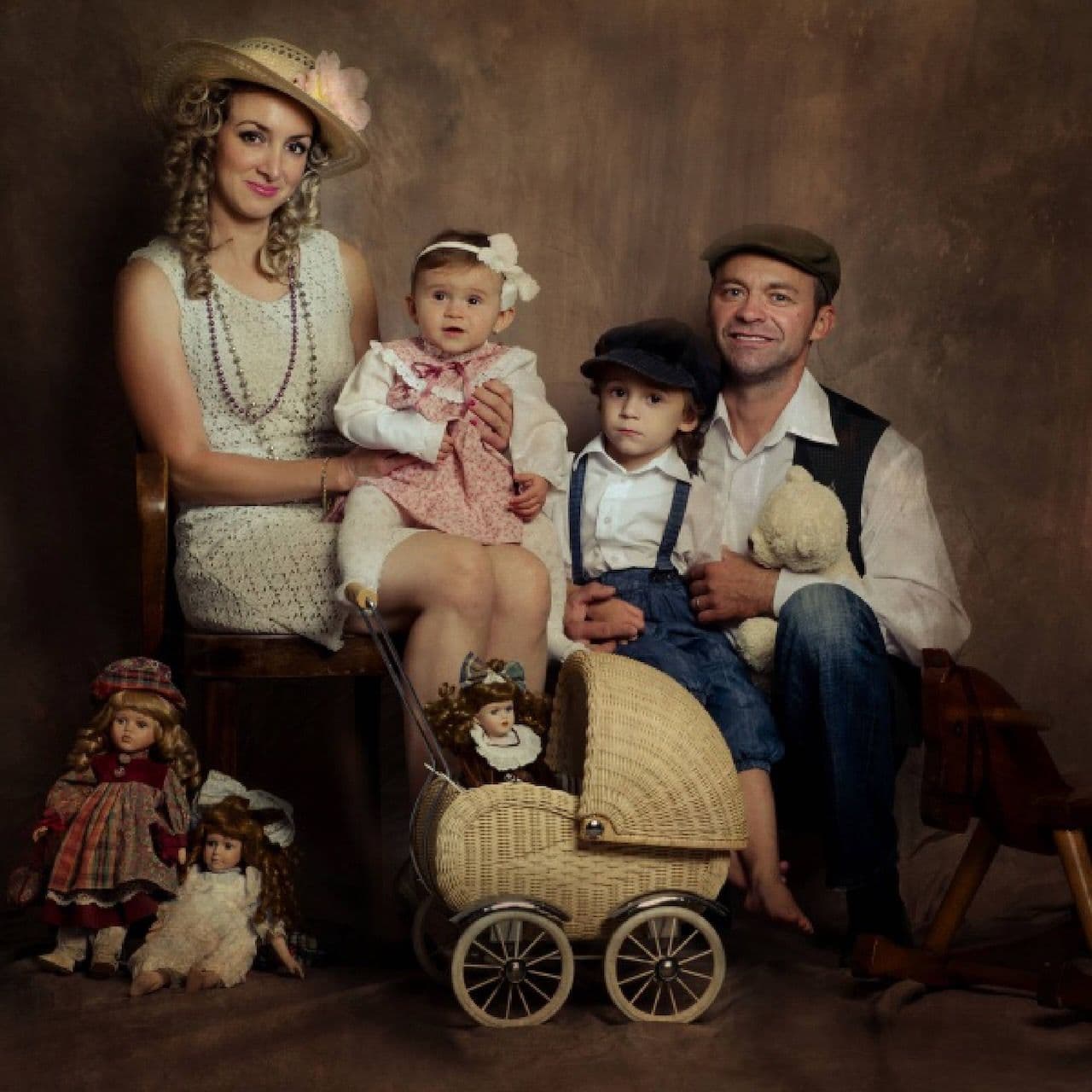 Vintage-styled family portrait with dolls and a pram