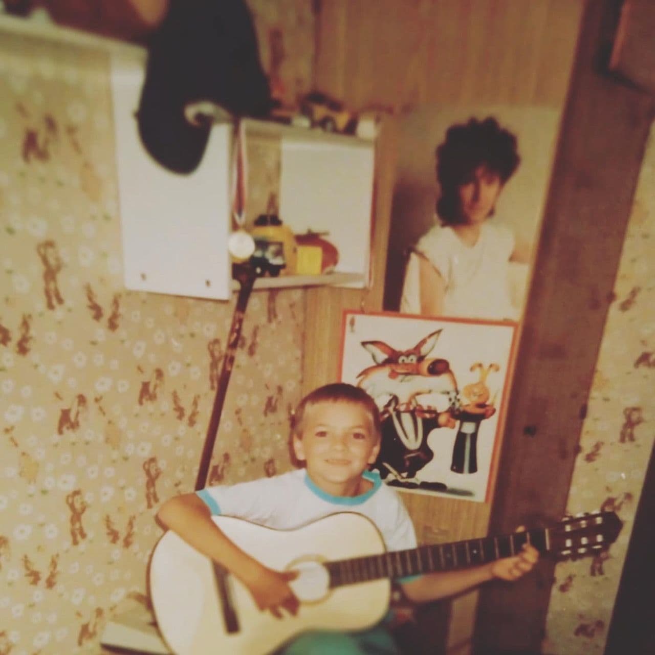 Miki as a boy playing guitar at home