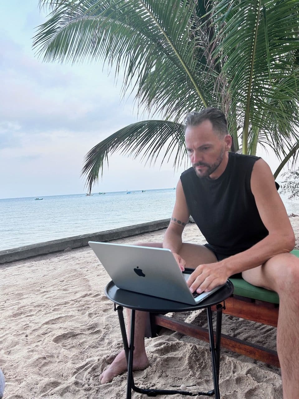 Working on a laptop on a tropical beach