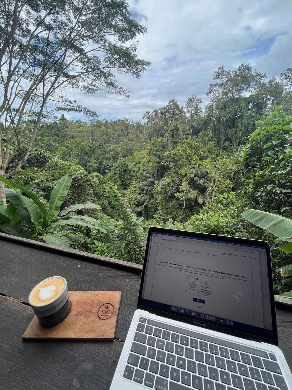 Laptop and coffee overlooking a jungle