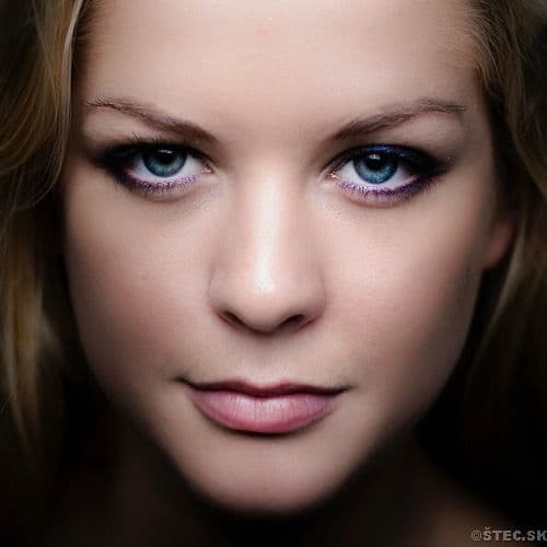Close-up studio portrait of a woman with blue eyes