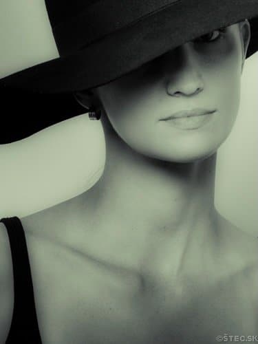 Portrait of a woman with her eyes hidden under a wide hat brim